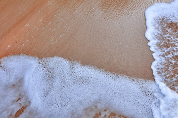 Fototapeta na wymiar Wave On Sandy Beach. Background. Splash of waves on the sandy beach. foam, surf, waves.