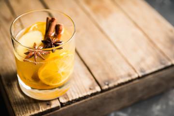 Healthy hot beverage with lemon, ginger and spices for protection in flu season. Selective focus. Shallow depth of field.