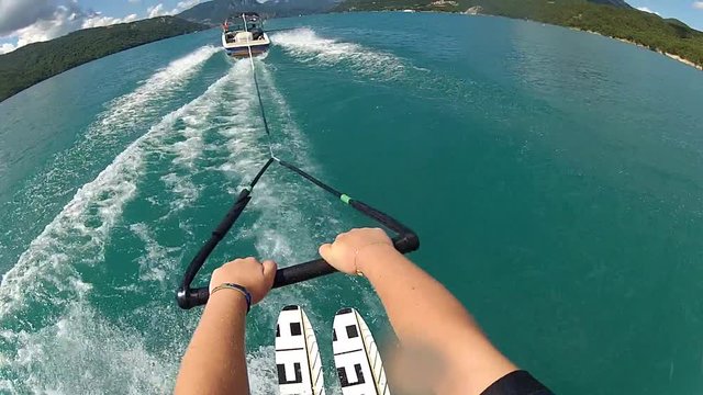 POV view of waterskiing. Water ski summer sports action camera, blue water lake.