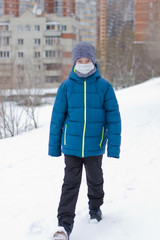 The danger of coronavirus. A boy on a walk walks in a medical mask on his face
