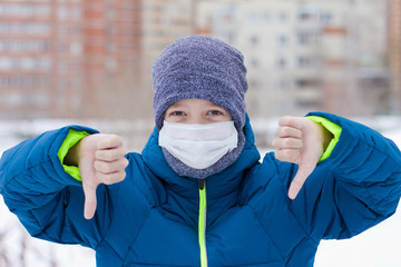 The danger of coronavirus. A boy on a walk walks in a medical mask on his face