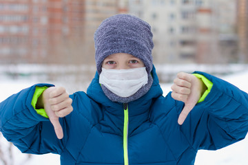 The danger of coronavirus. A boy on a walk walks in a medical mask on his face
