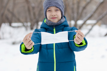 The danger of coronavirus. A boy on a walk walks in a medical mask on his face
