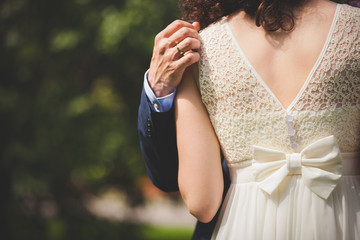 Obraz premium Man and woman hug while walking in the park on a sunny day after the registration of marriage. Happy couple in love spends time together. Love, marriage and happiness.