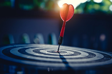 Bullseye(bull's-eye) or dart board has dart arrow hitting the center of a shooting target for...