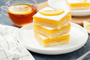Lemon bar dessert with powdered sugar and lemon slices