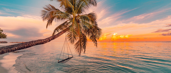 Wood swing beautiful sunset on the sea beach. Amazing tranquility 