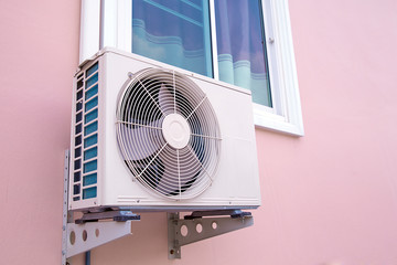 External air conditioner compressor unit are installed on the outside wall of the building.