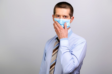 Sick man in medical mask, shirt covers his mouth with his hand
