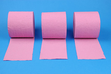 Rolls of pink toilet paper on a bright blue background