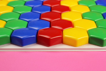 Children's Color puzzle, honeycomb mosaic on a pink background