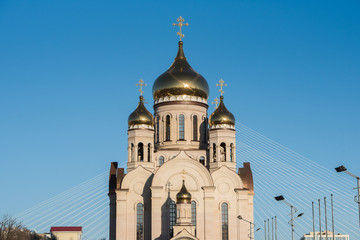 Eastern orthodox crosses on gold domes (cupolas) againts blue sunset sky.