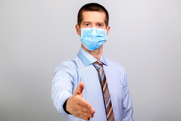 Man in medical mask, shirt extends his hand