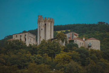 Castle of Beautiful castle of Branik or Rihemberk, viewed from below. Frog view of medieval castle with round tower hiding behind trees