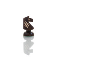 A view of knight black chess piece. Wooden chess pieces against white color background