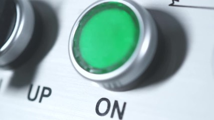 Green button power on. Finger pushing button. Start engine electrical equipment in industrial factory. Panel with green plastic round pressbutton. Beginning of work. Switch on. Turn on the electricity