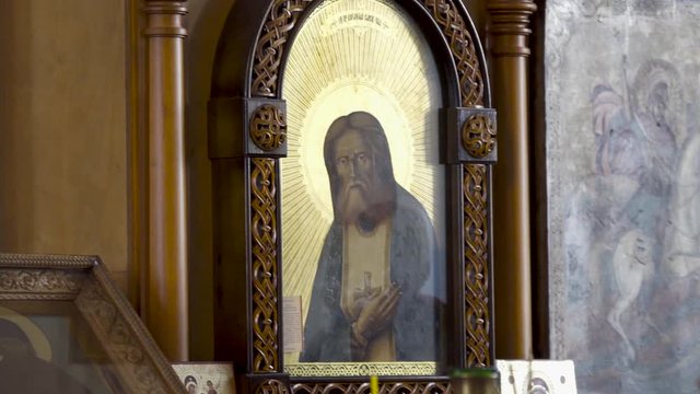 Man and woman at icon in Christian Church. Stock footage. Man tells believing woman about icon while conducting tour in Christian Church