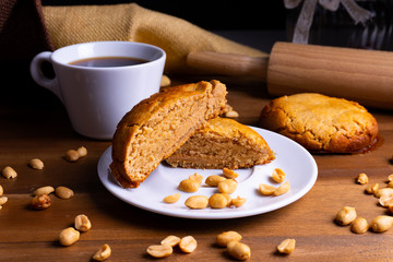 Fresh vegan cookie cakes with peanut butter, peanuts and a cup of coffee on a wooden board with copy 