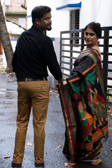 A brunette Indian Bengali romantic couple in traditional wear interacting between themselves in the...