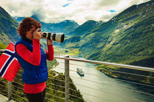 Tourist taking photo of fjord landscape, Norway