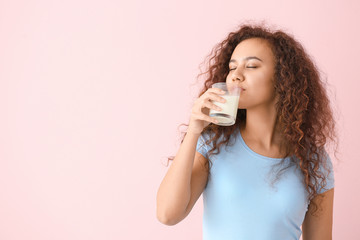 African-American woman with milk on color background