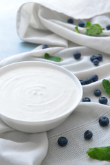 Bowl with tasty yogurt and berries on table