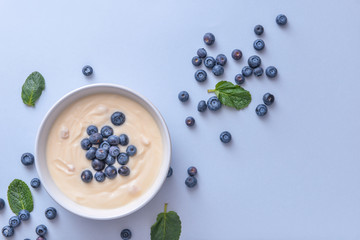 Bowl with tasty yogurt and berries on color background
