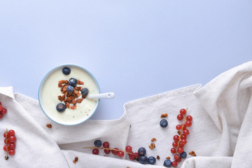 Obraz na płótnie Canvas Bowl with tasty yogurt, granola and berries on color background