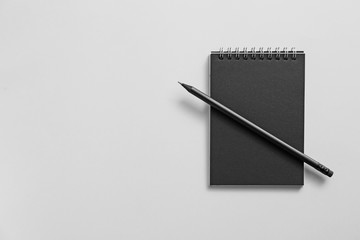Notebook with pencil on grey background