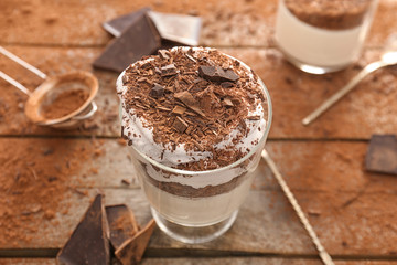 Glass with tasty panna cotta on table