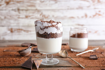 Glass with tasty panna cotta on table
