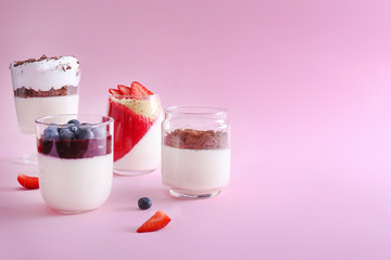 Glasses with tasty panna cotta on color background
