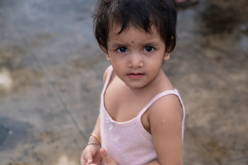 Portrait of a cheerful Indian kid enjoying on the rooftop in a summer afternoon. Indian lifestyle and childhood.