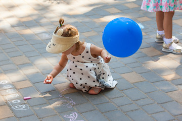 Little children draw with chalk on the pavement