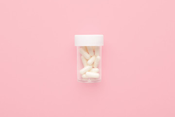 Jar with pills on color background