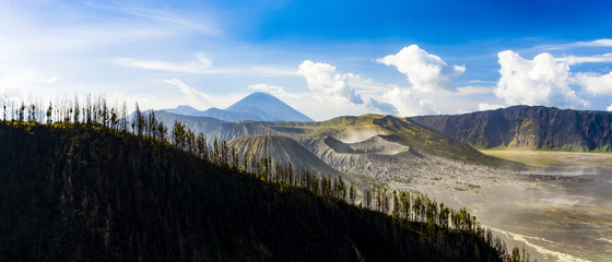 View from above, stunning aerial view of the Mount Bromo crater in the background and a silhouette of an hill in the foreground. Mount Bromo is an active volcano in East Java, Indonesia.