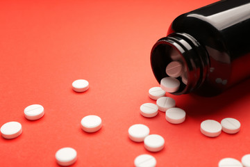 Jar with pills on color background