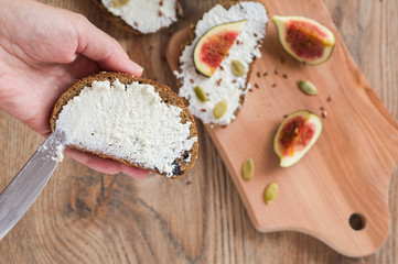 woman makes sandwiches with curd cheese and figs
