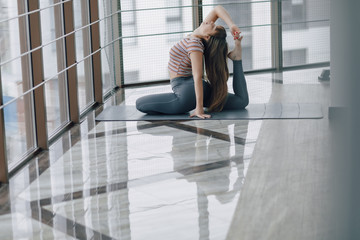 pretty attractive girl doing yoga and relaxing in the bright room