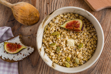 oatmeal with butter seeds and figs on a wooden table