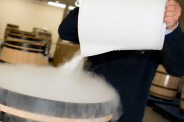 wood barrel with red grapes man put dry ice smoke to refresh in cellar