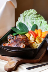 Roasted meat with potatoes and vegetables in a roasting dish.