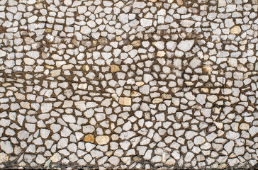 Fragment of a wall made of stones of different sizes held together with mortar, close-up, copy space.
