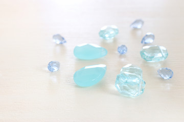 Delicate blue gemstones beads on white wooden background