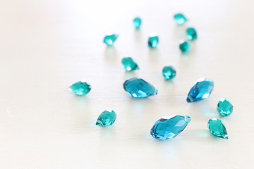 Beautiful blue and turquoise crystal drops beads over white wooden background