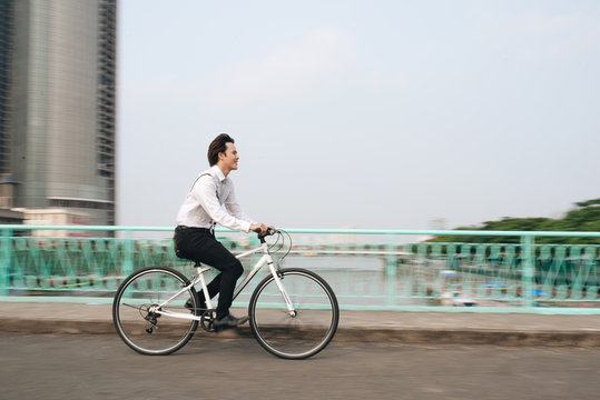 Blurred image of Asian man mad riding bicycle in urban city commuting with speed and hipster trendy transportation