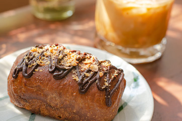 Cocoa bread topped with almonds on a wooden table