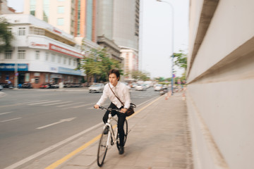 Blur concept. Hurry Asian businessman riding bike in rush hour.  Young man late for train work, meeting. Office life and business competition.