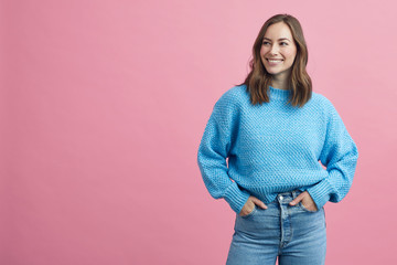 Sweet smiling girl, person and businesswoman in a winter sweater looking left at copy space, isolated on a colorful and coloured pink background. - 333643446