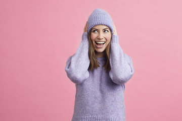 Young smiling woman looking happy and cute with purple sweater and matching hat, isolated on...